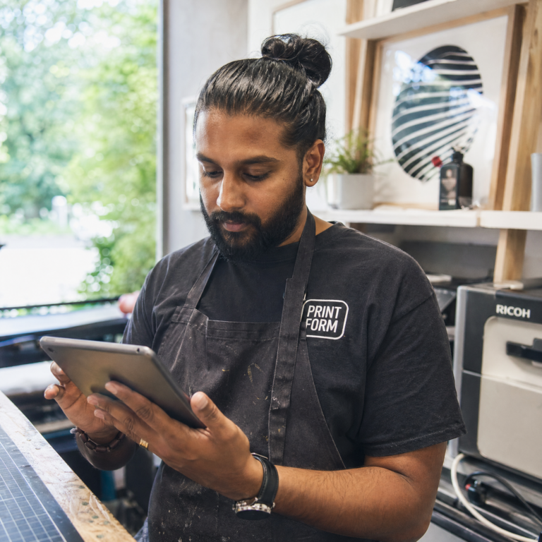 Self-employed worker checking right to work documentation on a tablet in their workspace