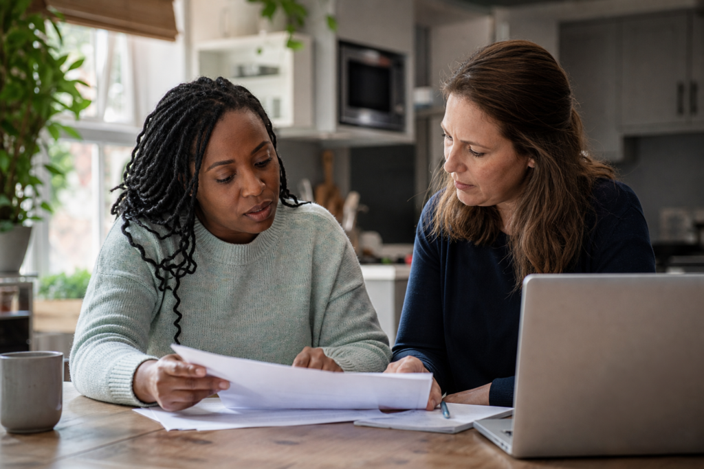 Private tutor and parent reviewing DBS documents at a kitchen table